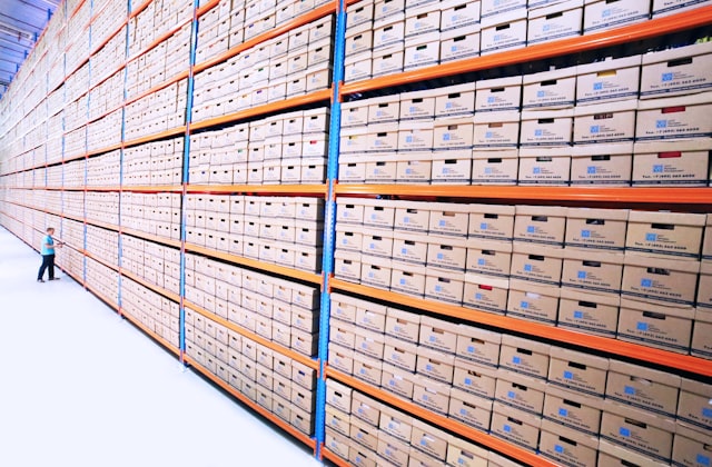 Rows of archived document boxes on warehouse shelving