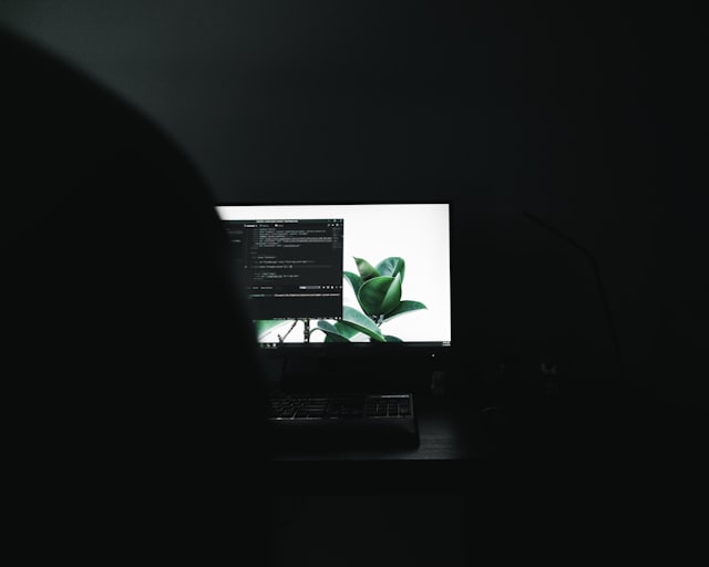 A monitor showing code in a dark room
